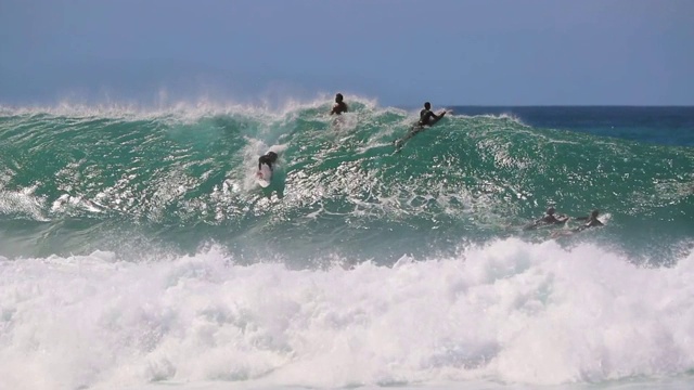 冲浪者和Bodyboarders在管道，夏威夷和一个冲浪者抓住一个浪潮视频素材