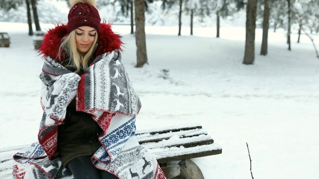 美丽的蓝眼睛金发女孩在白雪覆盖的树林里，视频素材