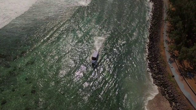 船沿着留尼汪岛海岸线移动，空中高角度视频素材