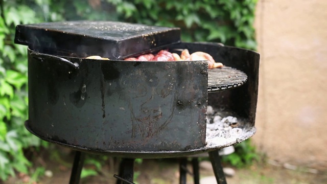 特写的阿根廷烧烤，而烹饪肉(asado)在花园的房子视频素材