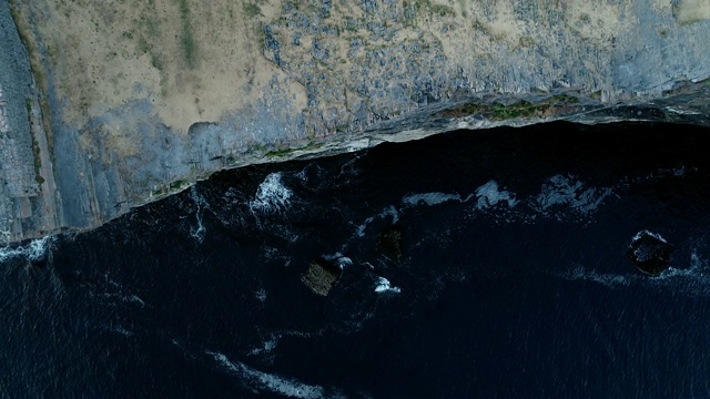 一架无人机在爱尔兰悬崖阿兰群岛的陆地上俯瞰大海视频下载