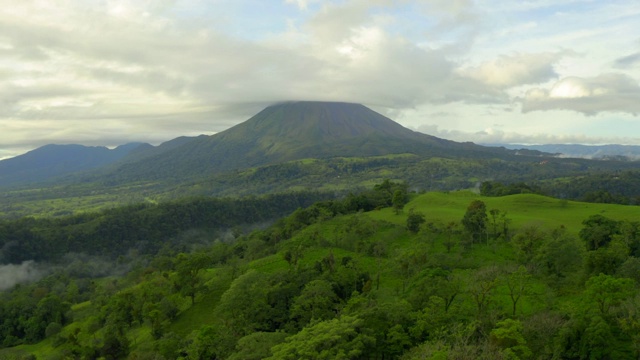 空中:美丽的、郁郁葱葱的、绿色的阿雷纳火山，在低矮的云层中视频素材