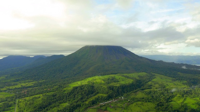 空中:巨大的绿色阿里纳斯火山在低矮的云层中视频素材