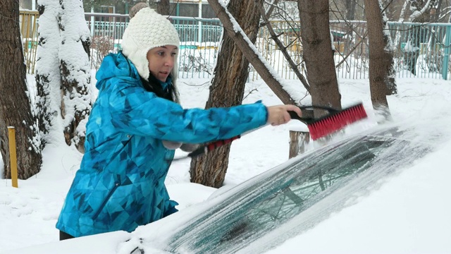 女孩在雪地里清理她的车视频下载