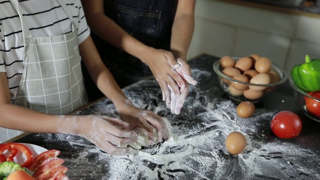 幸福家庭有爸爸，妈妈和他们的小女儿一起在厨房做饭视频素材