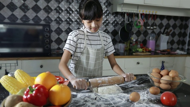 幸福家庭有爸爸，妈妈和他们的小女儿一起在厨房做饭视频素材