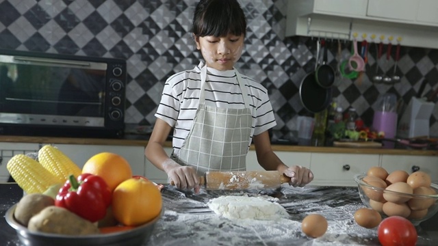 幸福家庭有爸爸，妈妈和他们的小女儿一起在厨房做饭视频素材