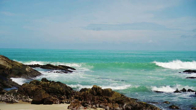 热带海滩，海浪，沙子和岩石与夏天的蓝天。视频素材