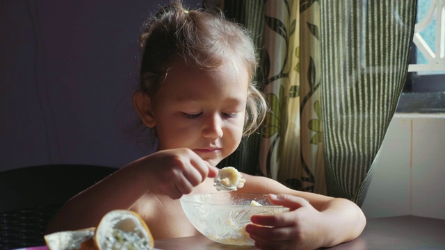 孩子正在吃早饭。可爱的小女孩吃粥的肖像。视频素材