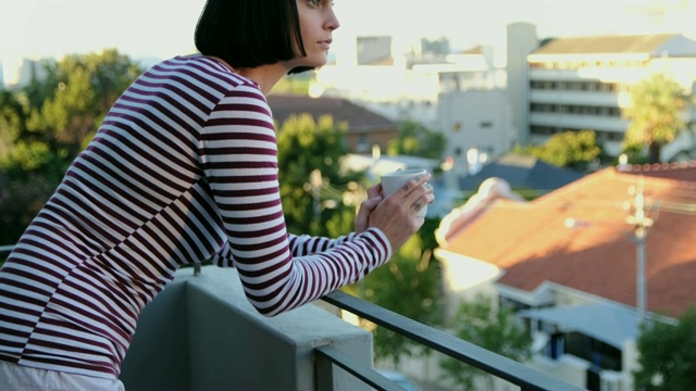 在阳台喝咖啡的女人视频素材