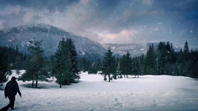 一名男子在雪山附近行走视频素材