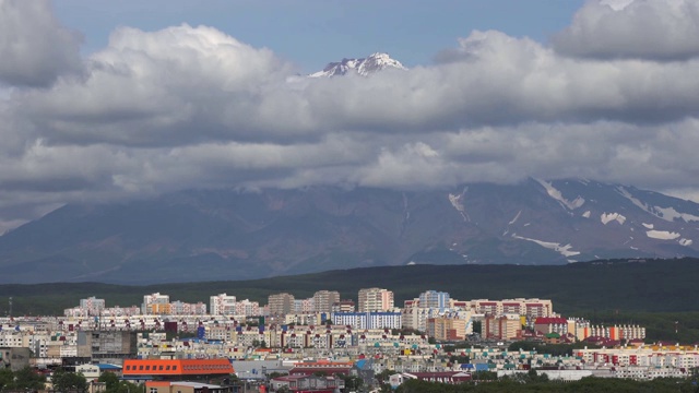 在阳光明媚的日子，火山云漂浮在天空上的夏季城镇景观视频素材