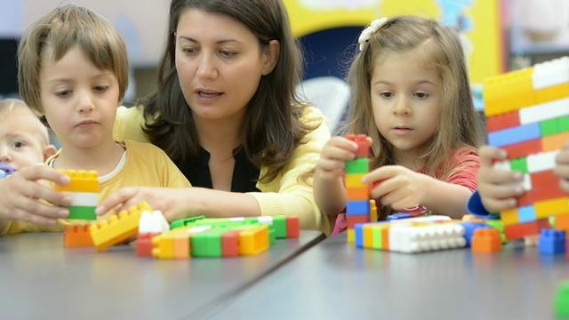 在幼儿园玩耍的孩子和教育者视频素材