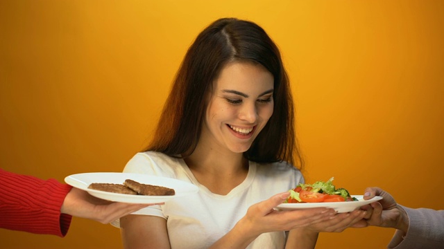 素食女孩选择新鲜的绿色沙拉而不是肉类，蔬菜中的维生素视频素材