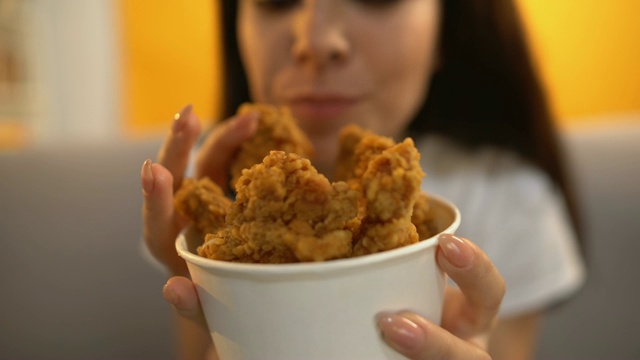 人给饥饿的女孩烤鸡翅，美味肥美的快餐视频素材