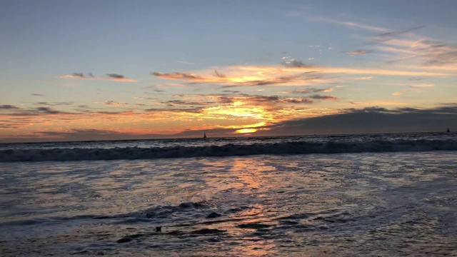 日落时海浪拍打着海岸视频素材