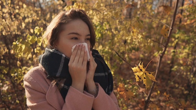 生病的女孩在室外打喷嚏。视频素材