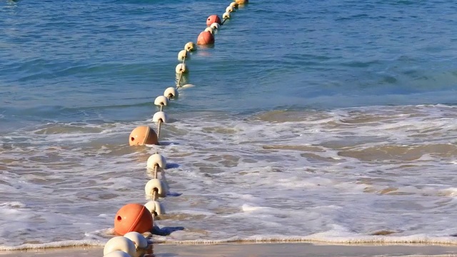 海上有波浪的浮标为游客游泳提供了安全区域视频素材