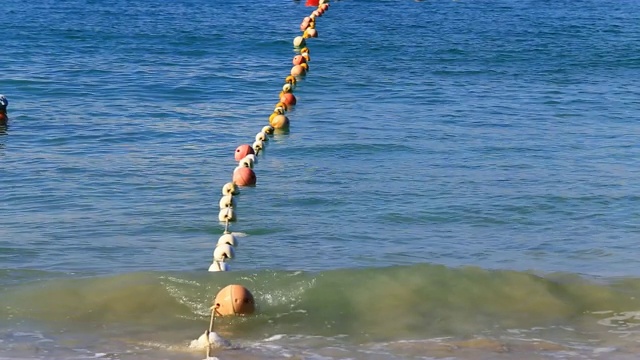 海上有波浪的浮标为游客游泳提供了安全区域视频素材