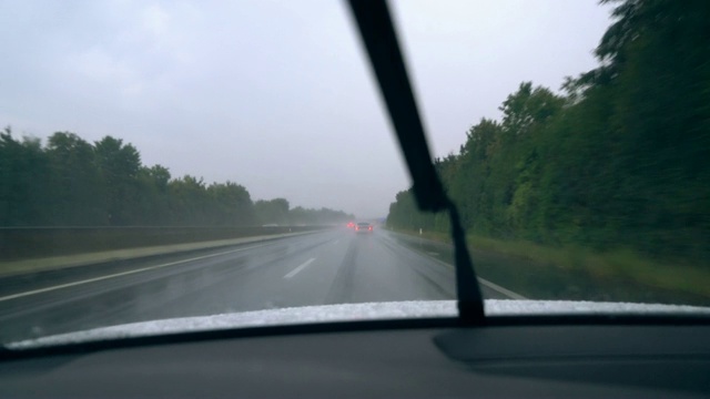 高速公路上行驶的汽车上的雨刷清除掉了汽车上的雨水视频素材