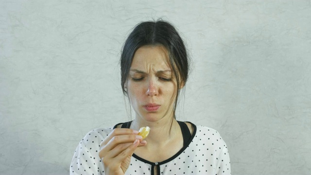 女孩脸上酸溜溜的表情。褐发女人吃着酸橙和肉。视频素材