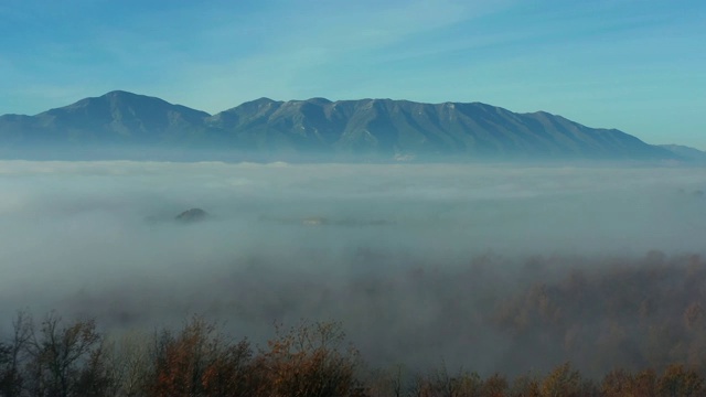 鸟瞰图的云和雾滩在森林与一些山的背景。视频素材