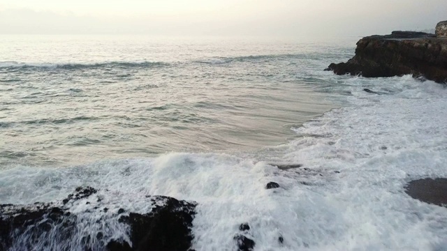 在阴天里，拉古纳海滩的海浪撞击着岩层视频素材