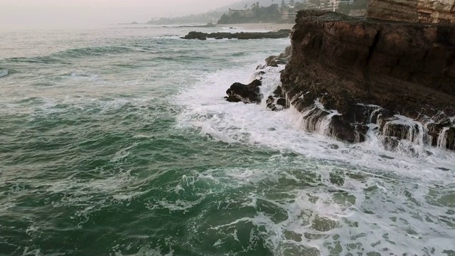 在加利福尼亚的拉古纳海滩上，海浪拍打着巨大的岩层视频素材