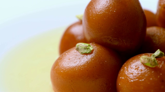 Gulab jamun旋转与开心果浇头(印度甜)|甜点|特写镜头视频素材