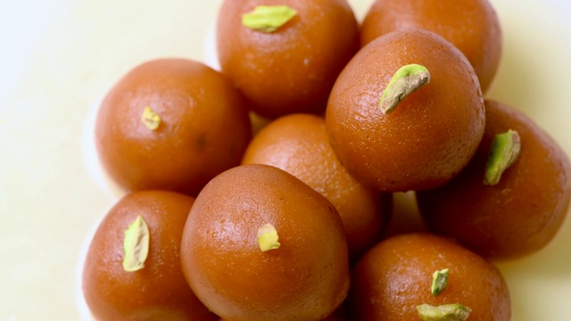 Gulab jamun旋转与开心果浇头(印度甜)|甜点|顶部和特写镜头视频下载