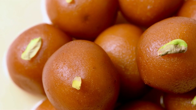 Gulab jamun旋转与开心果浇头(印度甜)|甜点|特写镜头视频下载