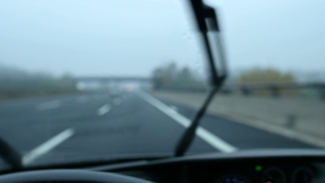 一辆汽车在阴雨天在高速公路上行驶的模糊视频。视频素材