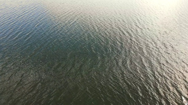 从高空俯瞰水的纹理。海浪和从上面看到的耀眼的太阳视频素材