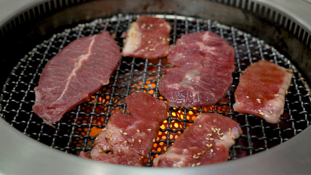 生牛肉片用于烧烤或日式烧肉，在日本的炉子上用木炭烧烤。视频素材