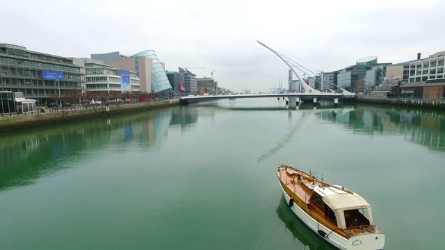 用无人机拍摄的距塞缪尔·贝克特桥(Samuel Beckett Bridge)附近的利菲河(River Liffey)，距离为4k视频素材