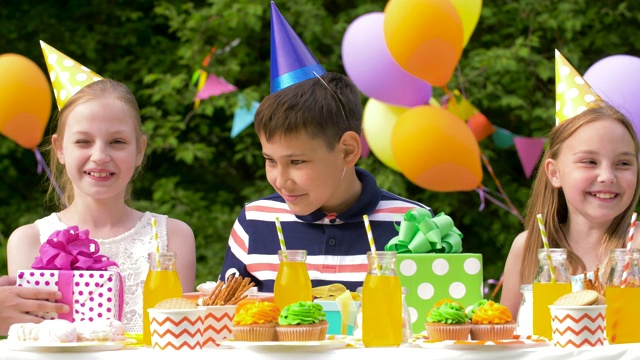 孩子们在聚会上给过生日的孩子送礼物视频素材