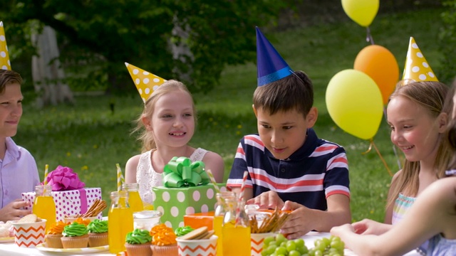 孩子们在聚会上给过生日的孩子送礼物视频素材