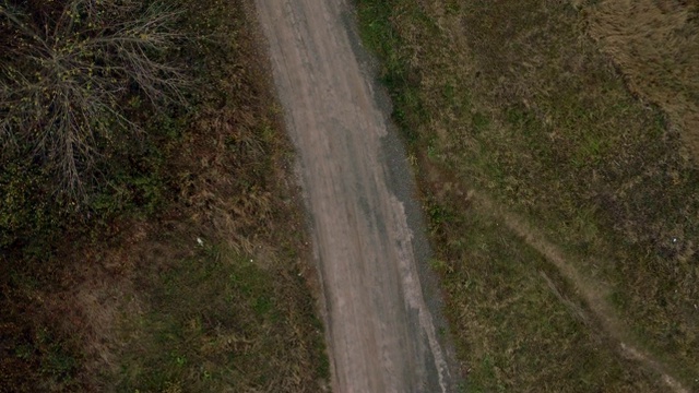 汽车在狭窄的道路上行驶的鸟瞰图。鸟瞰图的老黑色宝马在乡村道路上紧转弯视频下载