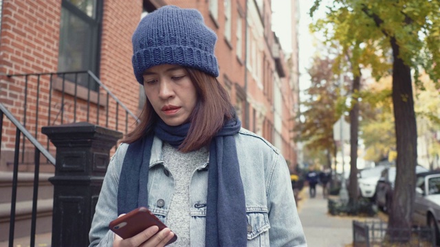 在户外玩智能手机的年轻女子。视频素材