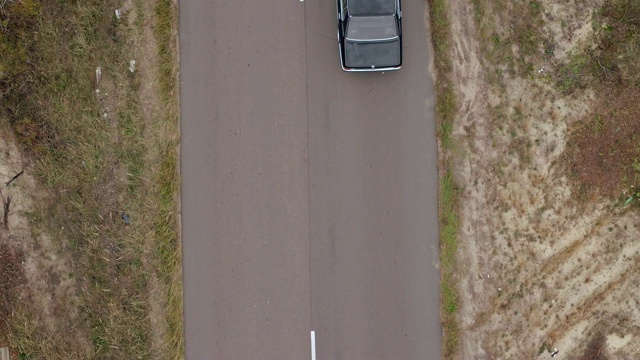 空中拍摄乡村公路上的汽车。鸟瞰图的老式黑色宝马在乡村道路上视频素材