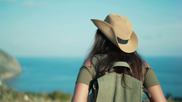 后视图背包女享受旅行接近美丽的海被山包围视频素材