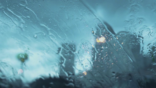 透过车窗与雨滴的道路视图。视频素材