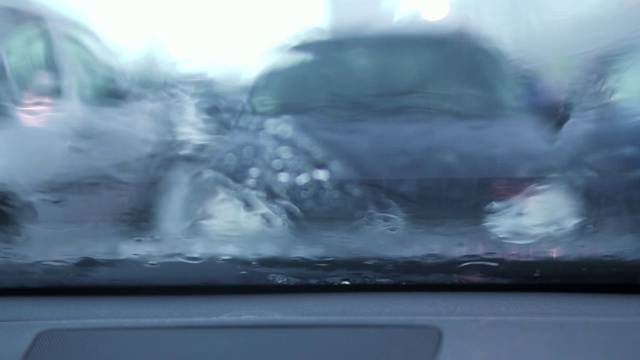 雨天从车里看。雨点打在车窗上，使外面的图像模糊视频素材