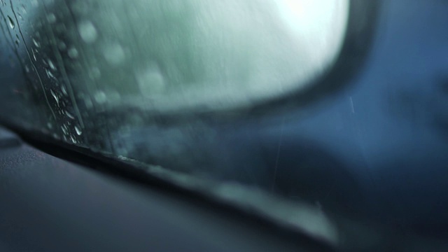 雨点落在车窗上关上。在雨天选择焦点水滴在汽车外的玻璃上视频素材