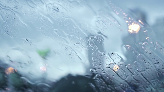 透过车窗与雨滴的道路视图。视频素材