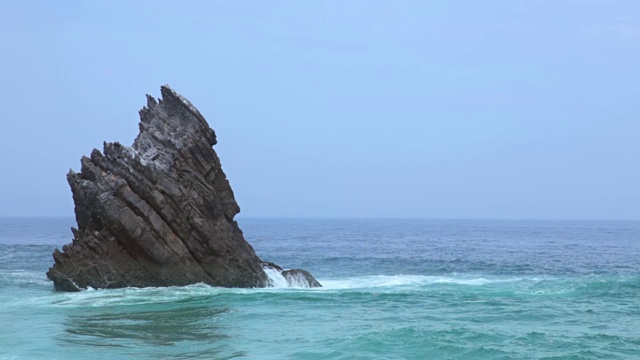 孤独的岩石在海洋和冲浪视频素材