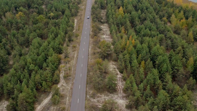 空中拍摄乡村公路上的汽车。鸟瞰图的老式黑色宝马在乡村道路上视频下载