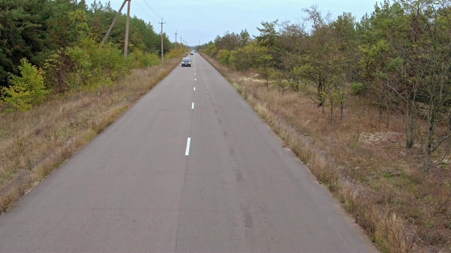 空中拍摄乡村公路上的汽车。鸟瞰图的老式黑色宝马在乡村道路上视频素材