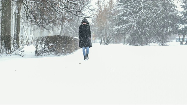 冬日里，女人冒着暴风雪在外面散步视频素材