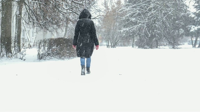 冬日里，女人冒着暴风雪在外面散步视频素材